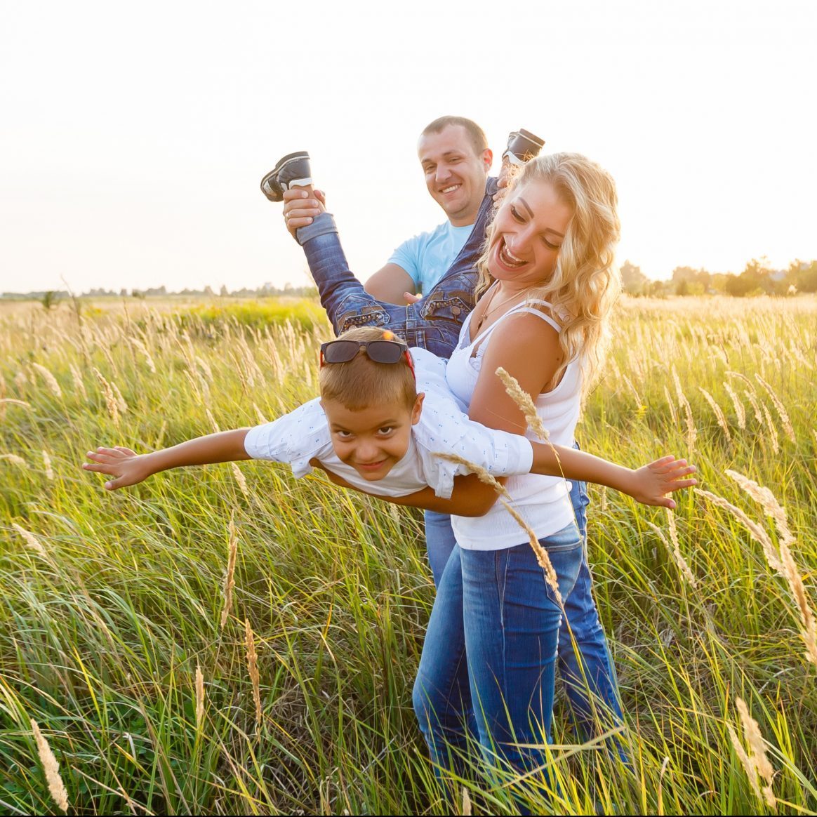 Happy family playing in a wheat field.